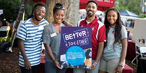 Students and staff holding "Better Together" poster