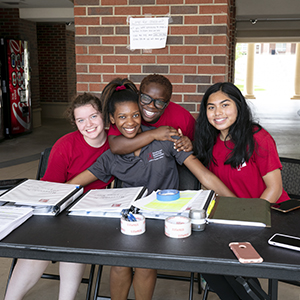 RAs sitting at welcome table for Move-In